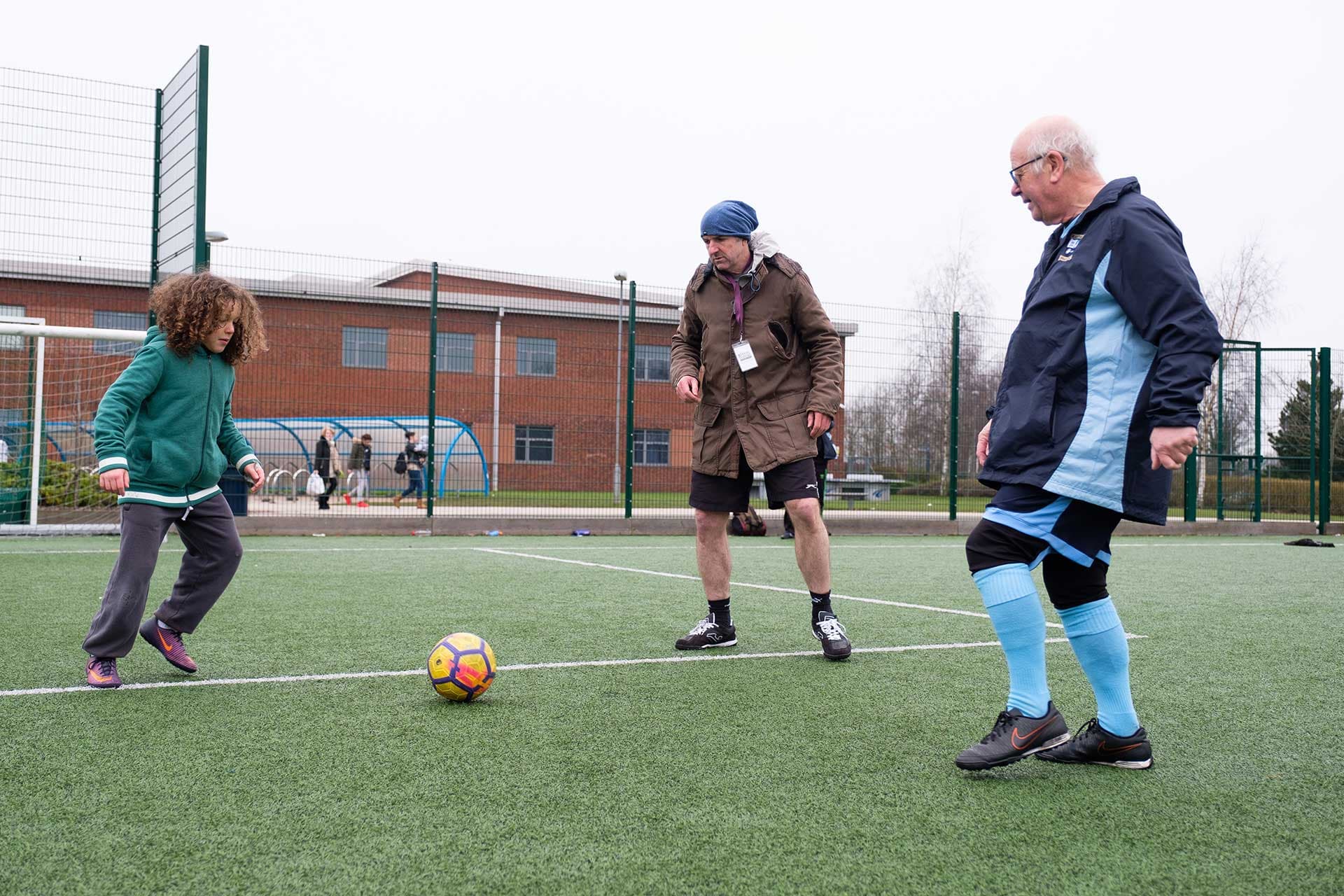 A caregiver playing football with an elderly client