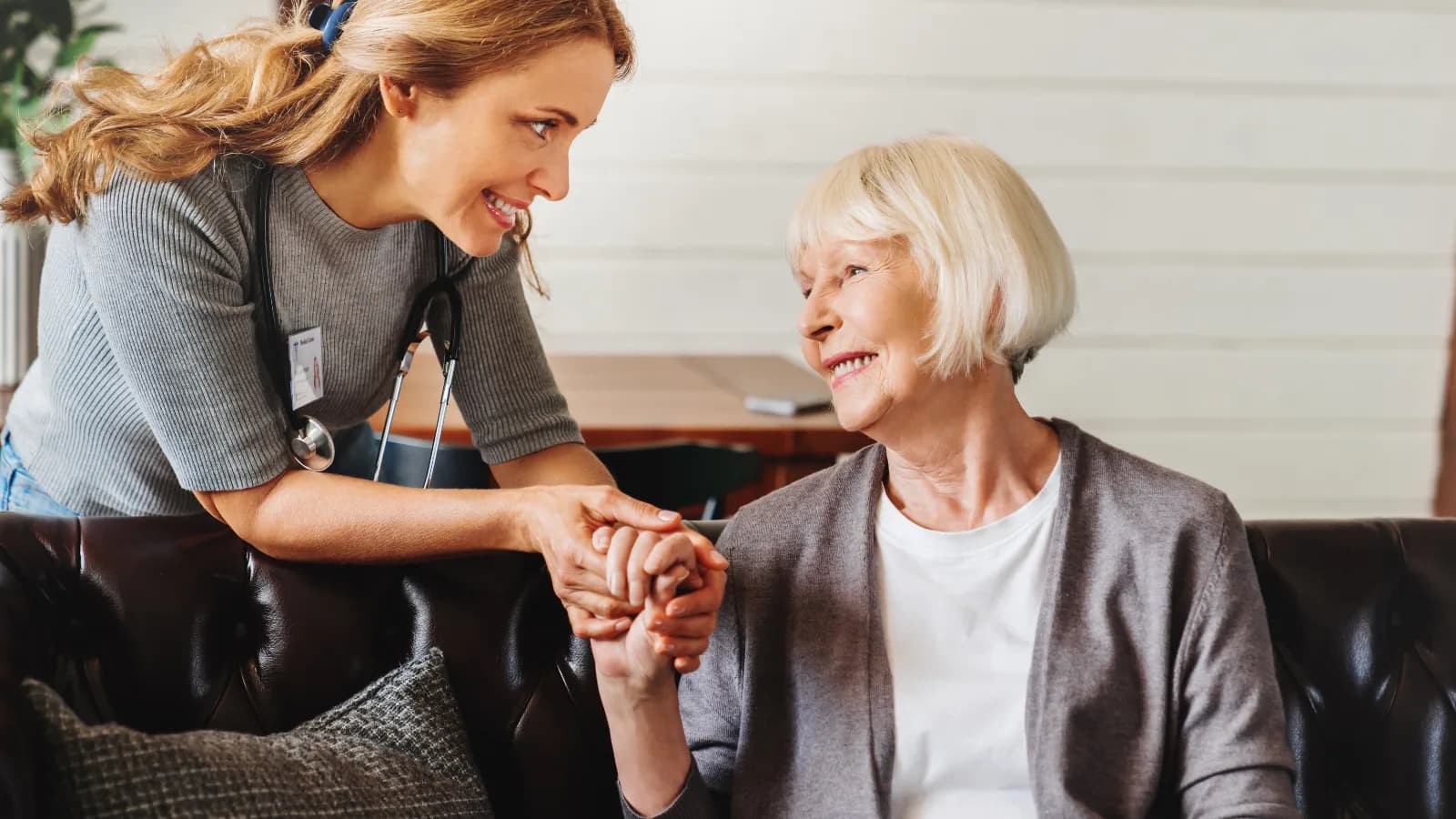 A caregiver holding hands with an elderly resident