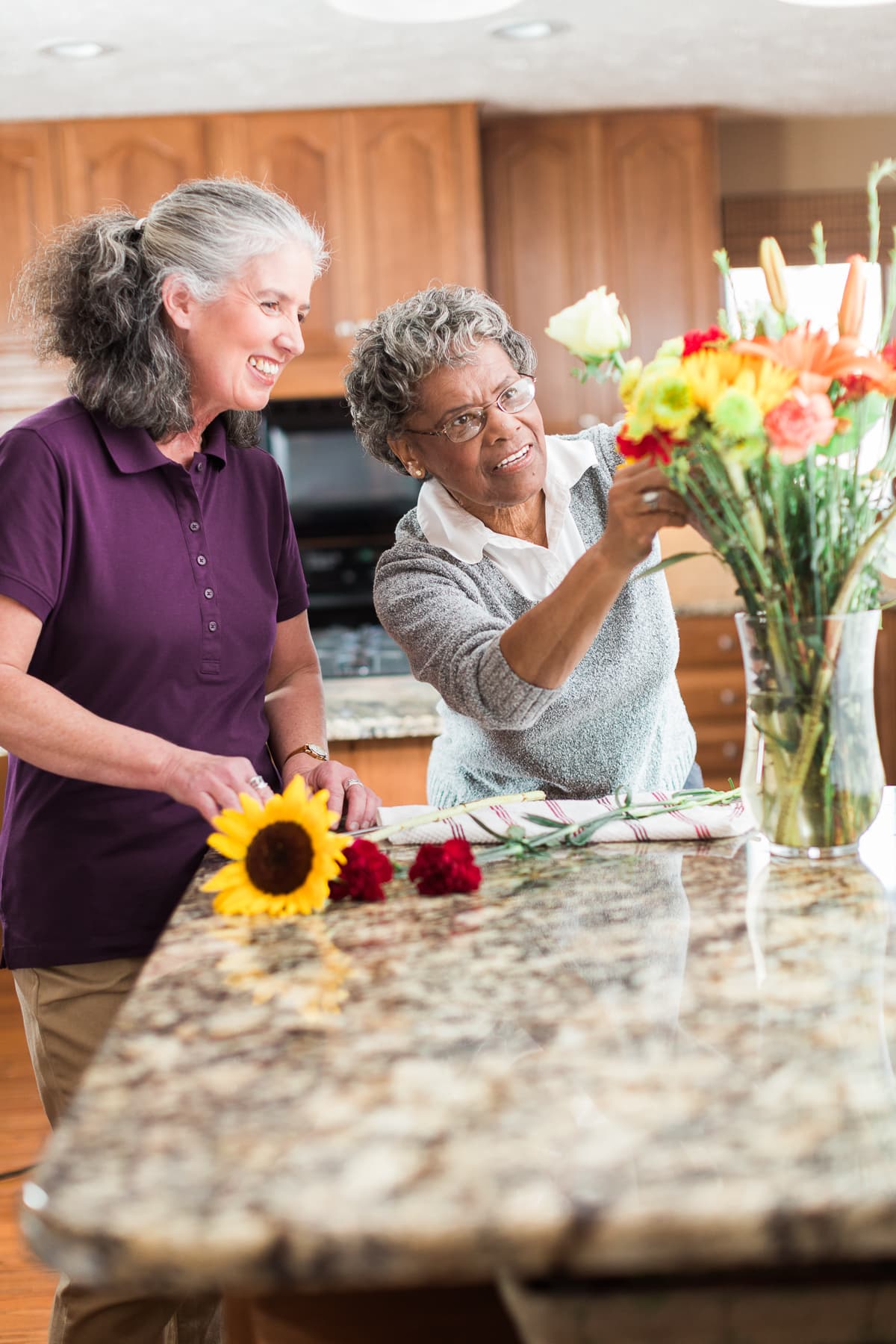 A caregiver and senior arranging flowers